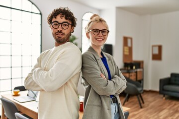Fototapeta premium Two business workers smiling happy standing with arms crossed gesture at the office.
