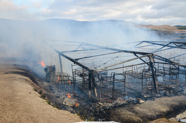 Fototapeta premium Burned object in nature. Damage after a large fire. Fire destroyed building.