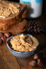Hazelnut buttercream in bowl. Shelled hazelnuts, bread and milk with fresh nut butter cream.