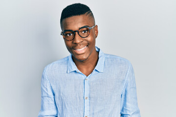 Young african american man wearing casual clothes and glasses with a happy and cool smile on face. lucky person.