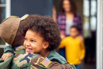 American Soldier In Uniform Returning Home To Family On Hugging Children Outside House