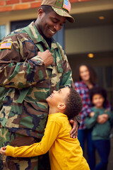 American Soldier In Uniform Returning Home To Family On Hugging Children Outside House
