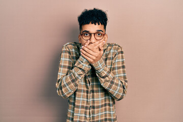 Young african american man wearing casual clothes and glasses shocked covering mouth with hands for mistake. secret concept.