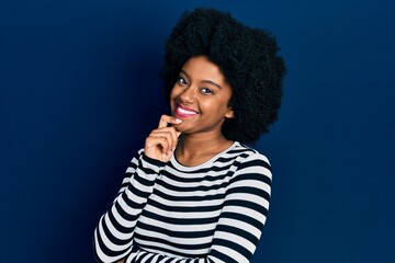 Young african american woman wearing casual clothes looking confident at the camera with smile with crossed arms and hand raised on chin. thinking positive.