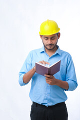 Young indian engineer wearing hardhat and watching diary