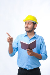 Young indian engineer wearing hardhat and watching diary