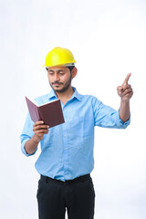 Young indian engineer wearing hardhat and watching diary
