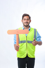 Young indian man holding a empty sign board on white background. construction work concept