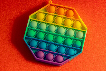 Close up shot of octagon pop it toy on colorful background. Indoors