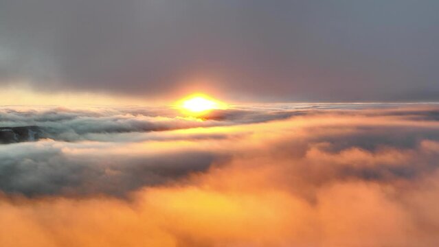 Sunset video over the clouds, sun paints the sky orange at the perfect golden hour time