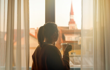 Woman with mug enjoying her vacations in old city.