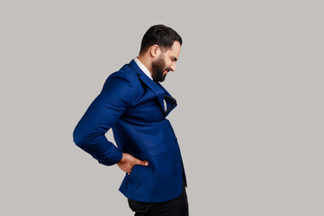 Side view portrait of bearded man standing with closed eyes, suffering lower back pain, kidney...