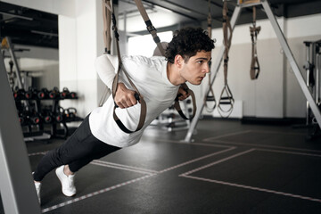 Fototapeta na wymiar A male athlete does cardio exercises training in the gym