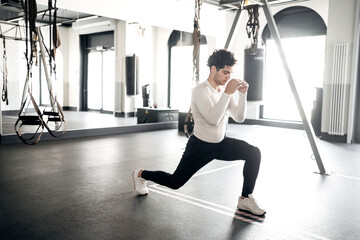 Fototapeta premium A male athlete does cardio exercises training in the gym