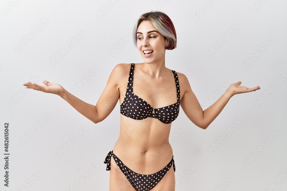 Sticker Young beautiful woman wearing swimsuit over isolated background smiling showing both hands open palms, presenting and advertising comparison and balance