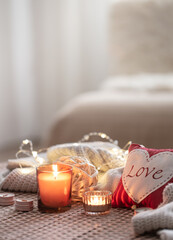 Fototapeta na wymiar Cozy Valentine's Day background with a candle and a decorative heart.
