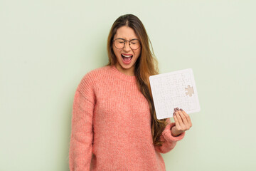 asian pretty woman shouting aggressively, looking very angry. puzzle concept