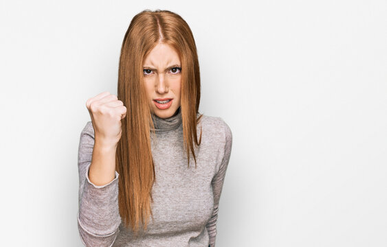 Young irish woman wearing casual clothes angry and mad raising fist frustrated and furious while shouting with anger. rage and aggressive concept.