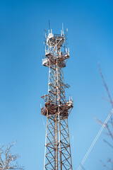 A TV tower covered with snow on a blue sky background