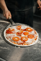 the chef prepares pizza for baking and selling in a restaurant 