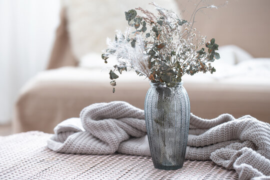 Home Composition With A Glass Vase With Dried Flowers On A Blurred Background.