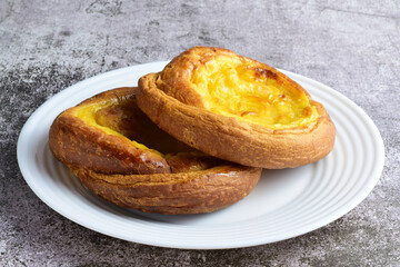 Sweet. White porcelain plate with two ensaimadas covered with burnt cream, typical of Spain