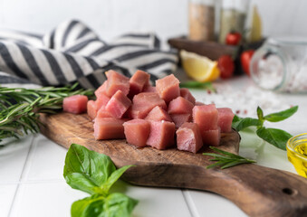 raw tuna fillet cut into cubes . marine predatory fish, family of mackerel. beautiful serving with fresh vegetables and spices