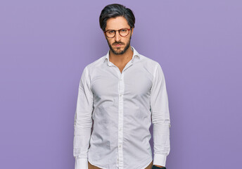 Young hispanic man wearing business shirt and glasses skeptic and nervous, frowning upset because...