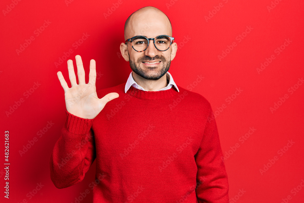 Sticker young bald man wearing casual clothes and glasses showing and pointing up with fingers number five w