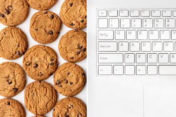 ノートパソコンのキーボードとクッキー。デジタルデバイスのCookieイメージ