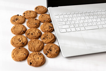ノートパソコンのキーボードとクッキー。デジタルデバイスのCookieイメージ