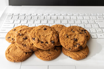 ノートパソコンのキーボードとクッキー。デジタルデバイスのCookieイメージ