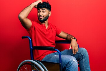 Arab man with beard sitting on wheelchair smiling confident touching hair with hand up gesture, posing attractive and fashionable