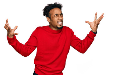 Young african american man with beard wearing casual winter sweater crazy and mad shouting and yelling with aggressive expression and arms raised. frustration concept.