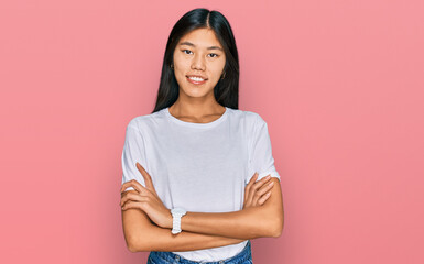 Beautiful young asian woman wearing casual white t shirt happy face smiling with crossed arms looking at the camera. positive person.