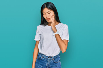 Beautiful young asian woman wearing casual white t shirt touching mouth with hand with painful expression because of toothache or dental illness on teeth. dentist