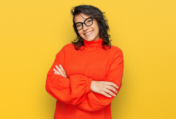 Young hispanic woman wearing casual clothes and glasses happy face smiling with crossed arms...