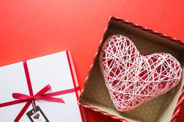 valentine's day. open gift box with big heart on red background. concept of giving love