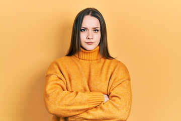 Young hispanic girl wearing casual clothes skeptic and nervous, disapproving expression on face with crossed arms. negative person.