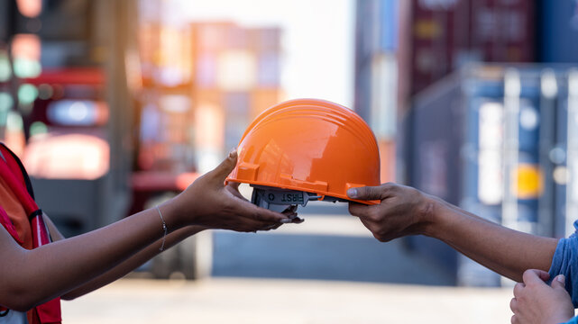 African american woman get safety helmet from Woman CEO cargo container warehouse on activity safety day, assign taske to foreman