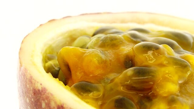 4K cross-section of a puple passion fruit Macro shot of sliced fresh exotic passion fruit fruit rotating  isolated on white background