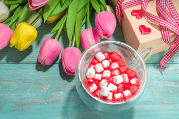 Heart shaped cup with red velvet hot chocolate, with small marshmallows, gift box and flowers for Valentine's day