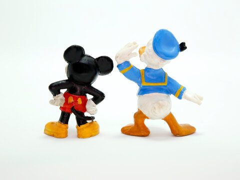 Mickey Mouse and Donald Duck. Friends. Walt Disney cartoon characters.  Plastic doll. Vintage. Isolated.   Classic Mickey. Back view. 
Looking at the horizon. Looking for something.