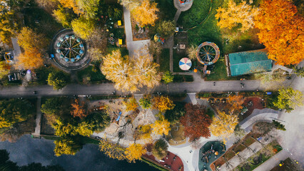 Top view of European autumn park with playground, swings and benches for people