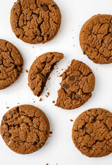 Chocolate chip cookies on a white background. Delicious homemade chocolate chip cookies beautifully laid out on a white background. Cracked cookies and crumbs on vertical photo