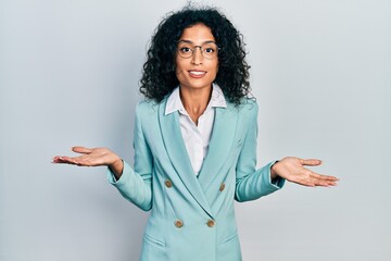Young latin girl wearing business clothes and glasses clueless and confused expression with arms...