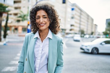 Young hispanic business woman wearing professional look smiling confident at the city