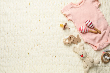 Different baby stuff on light knitted fabric, flat lay. Space for text