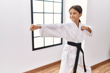 Young hispanic girl doing martial arts at training studio