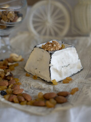 Various types of cheese with white mold on packaging paper. Home production, natural products.